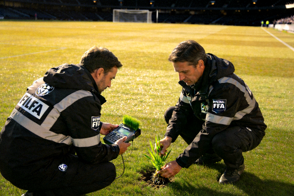 国际足联工作人员检查球场草皮质量